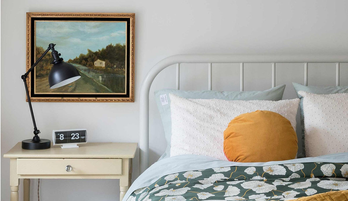 White bed with green bedding.
