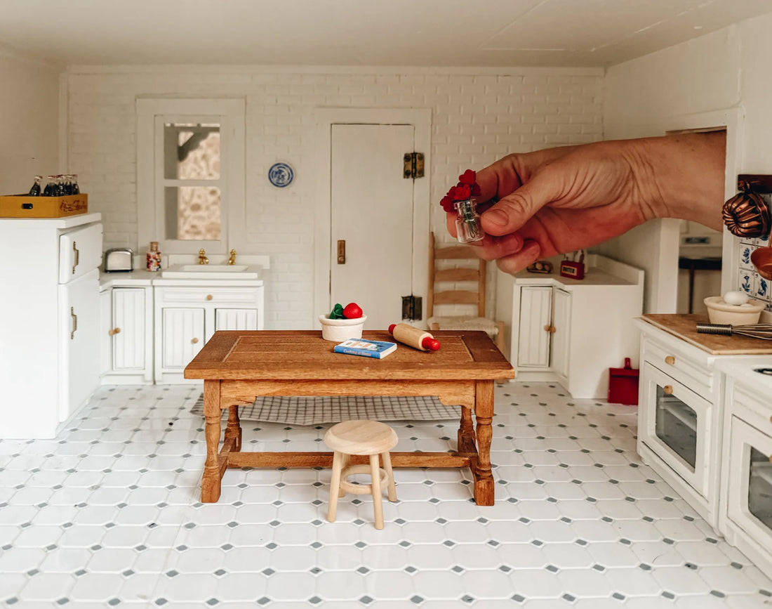 Hand inside a dollhouse.