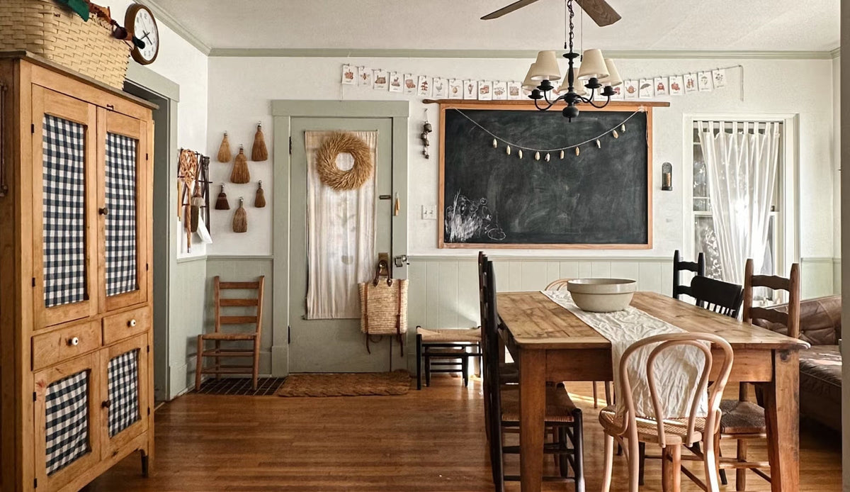 Farmhouse styled dining room with wooden dining table, chalkboard and wood cabinet