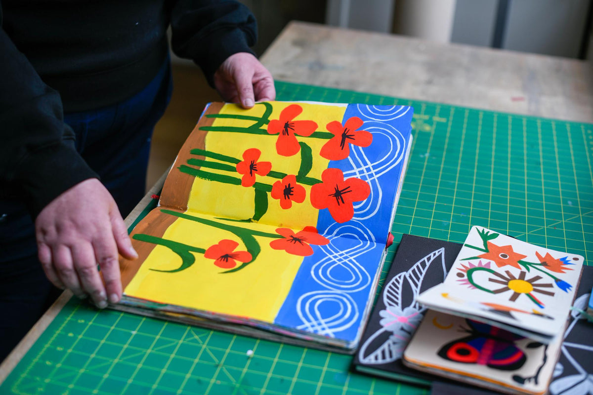 Open journal with red flowers on yellow and blue backdrop