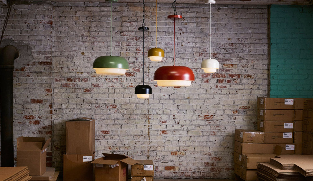 5 pendant lamps in different colors in front of brick wall