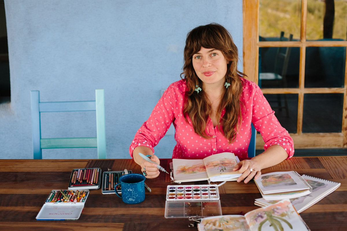 Artist sitting with their painting book and watercolors