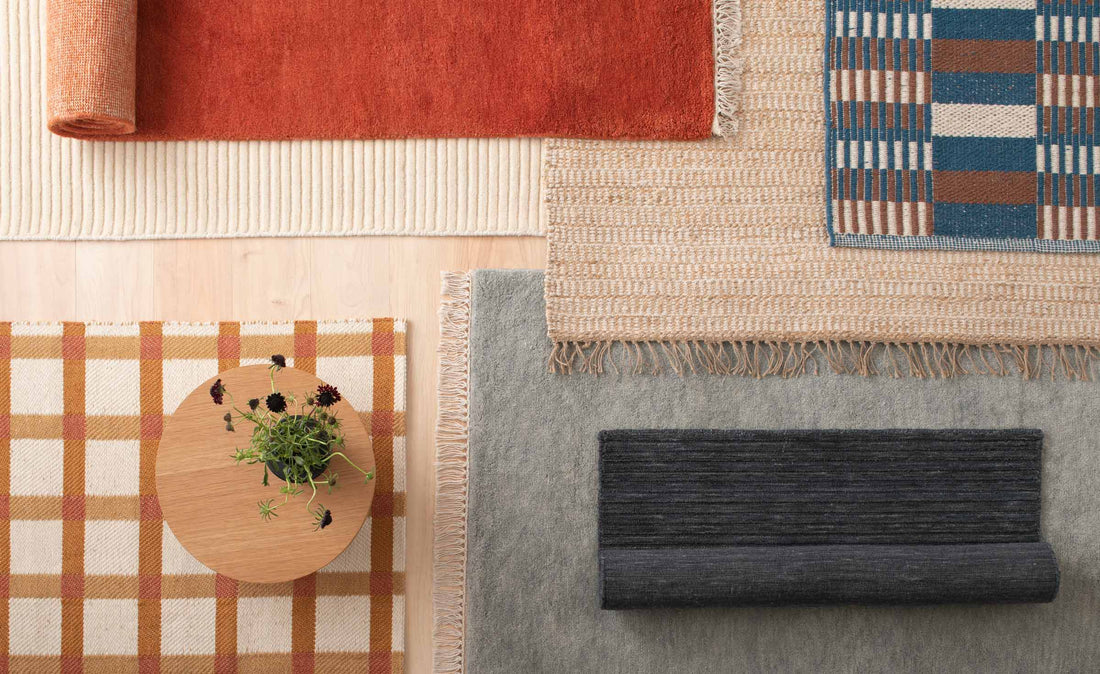 Overhead of six rugs showing varied textures and patterns on a light wood floor