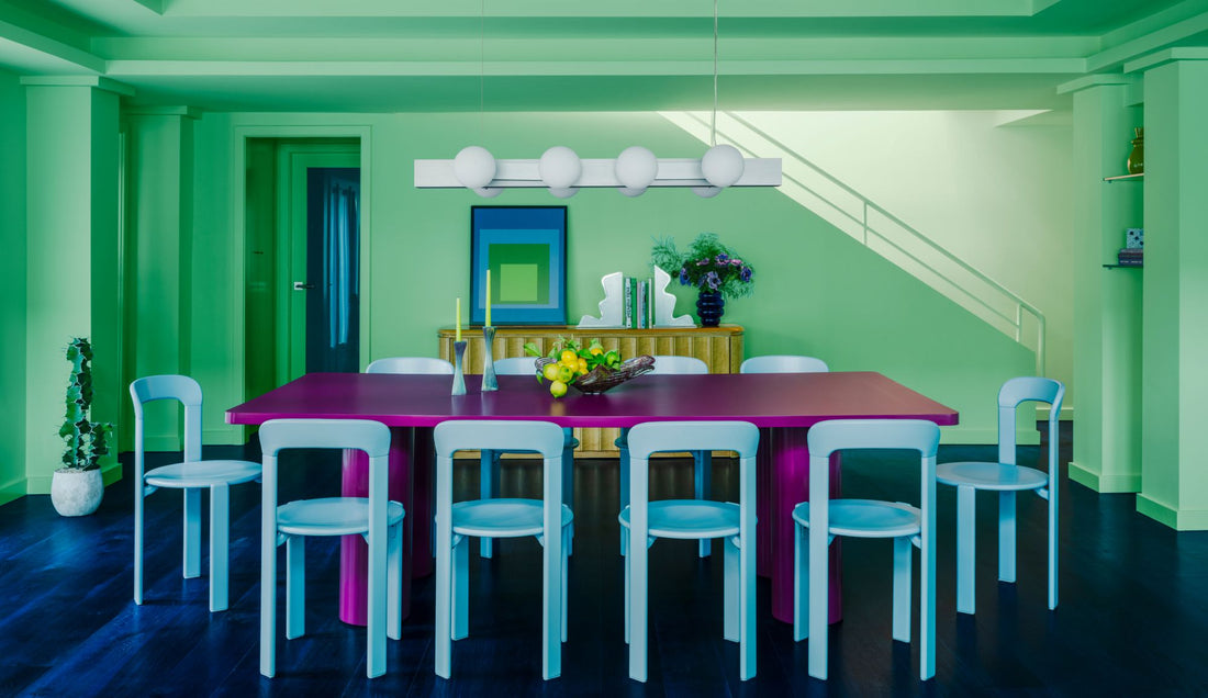 green painted dining room with magenta table and sky blue chairs