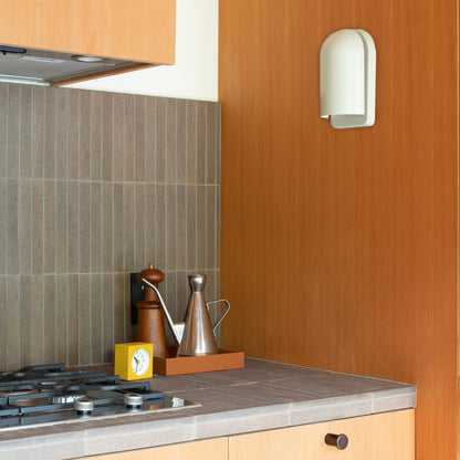 Right-side view of Allegheny Slim Sconce showing slim curved white shade mounted on a warm wood kitchen wall