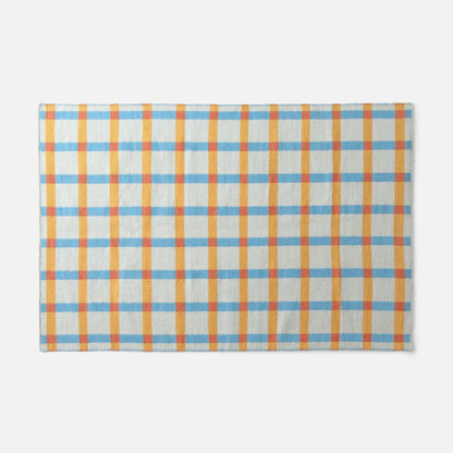 Top-edge view of Plaid Wool Reversible Rug showcasing blue, yellow, and orange plaid handwoven wool on white background