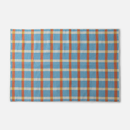 Top-edge close-up of Plaid Wool Reversible Rug showing blue, orange and yellow plaid handwoven wool texture on white