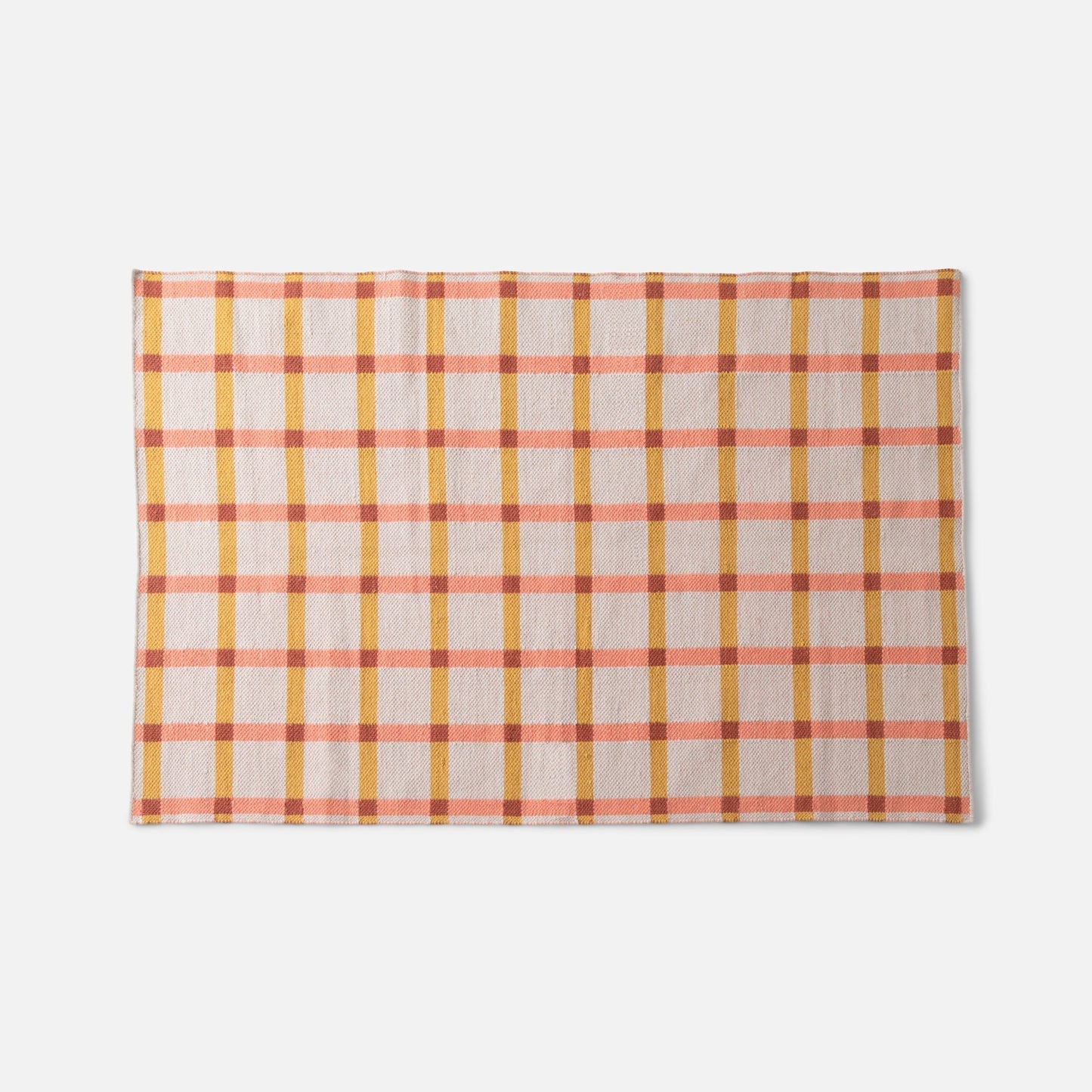 Top edge view of Plaid Wool Reversible Rug showcasing peach and mustard plaid, handwoven wool texture on white background