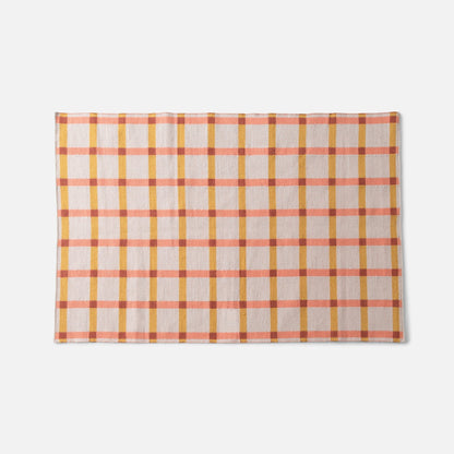 Top edge view of Plaid Wool Reversible Rug showcasing peach and mustard plaid, handwoven wool texture on white background