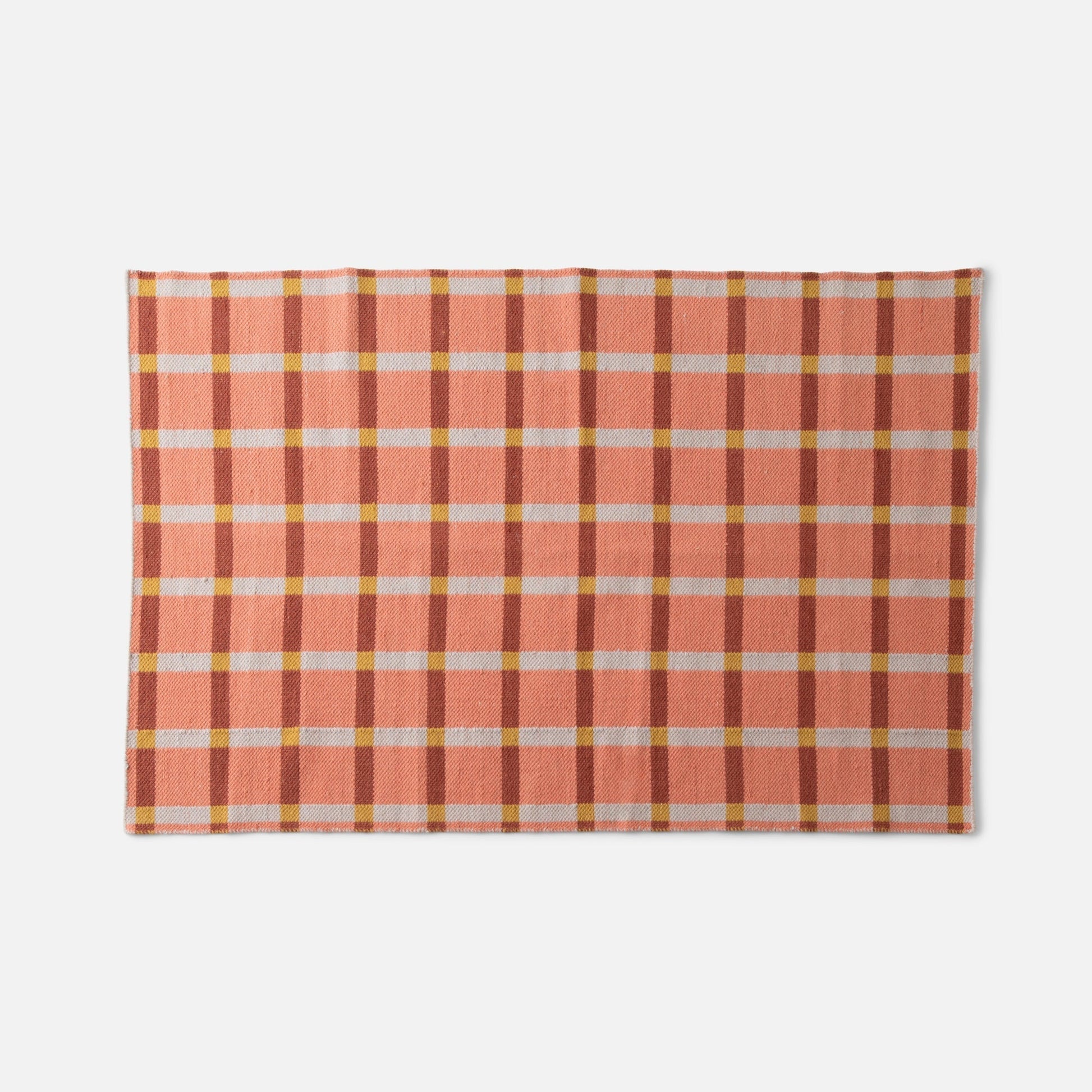 Top view of Plaid Wool Reversible Rug showing peach and rust high-contrast plaid handwoven wool on white background