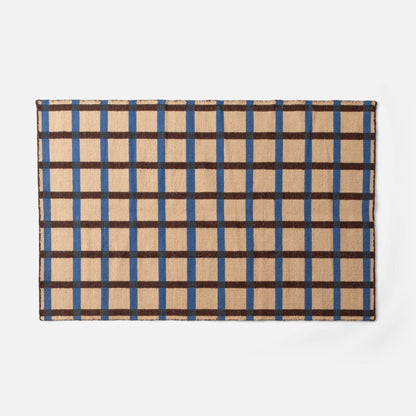 Flat lay of Plaid Wool Reversible Rug showcasing beige plaid with blue and brown checks and woven wool texture on white background