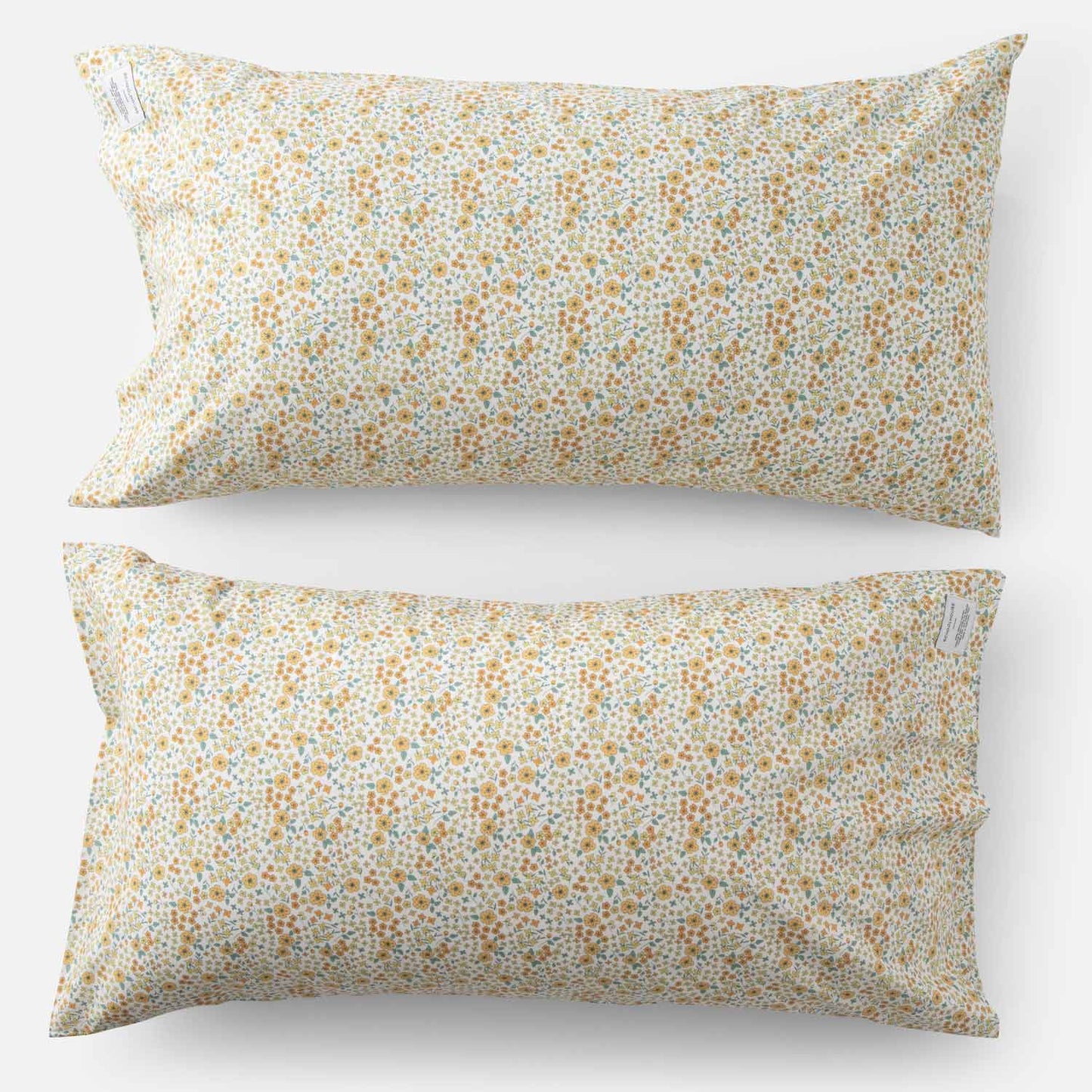 Top-down of two Wallowa Floral percale pillowcases (set of 2) showing small chamomile wildflower print on white background