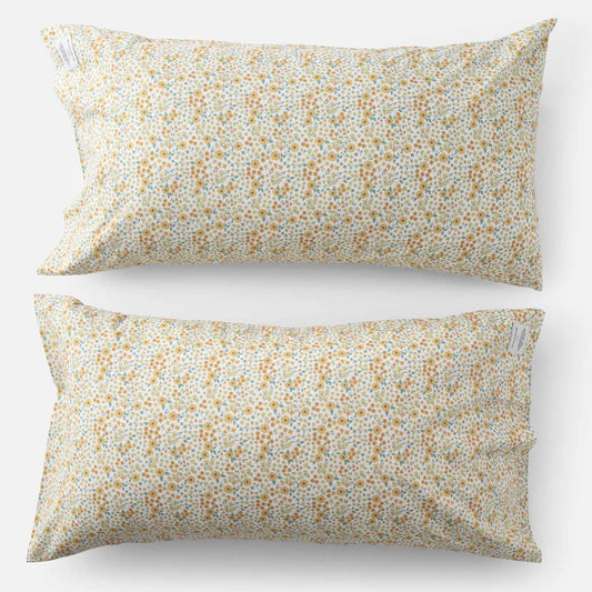 Top-down of two Wallowa Floral percale pillowcases (set of 2) showing small chamomile wildflower print on white background