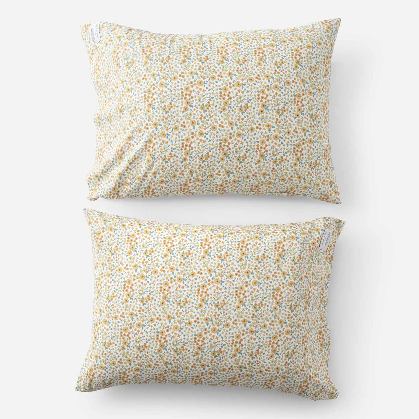 Top-down view of Wallowa Floral Percale pillow case set of 2 showing small yellow chamomile floral print on white percale