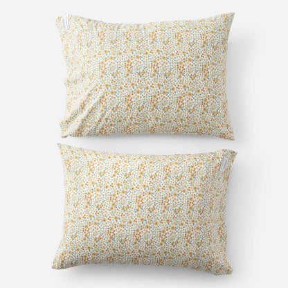 Top-down view of Wallowa Floral Percale pillow case set of 2 showing small yellow chamomile floral print on white percale