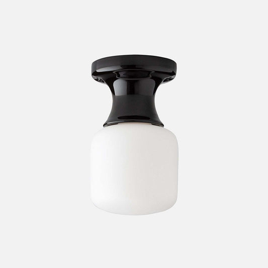 Front view of Alabax small flush mount showing black glazed ceramic base and white rounded shade against a light gray background