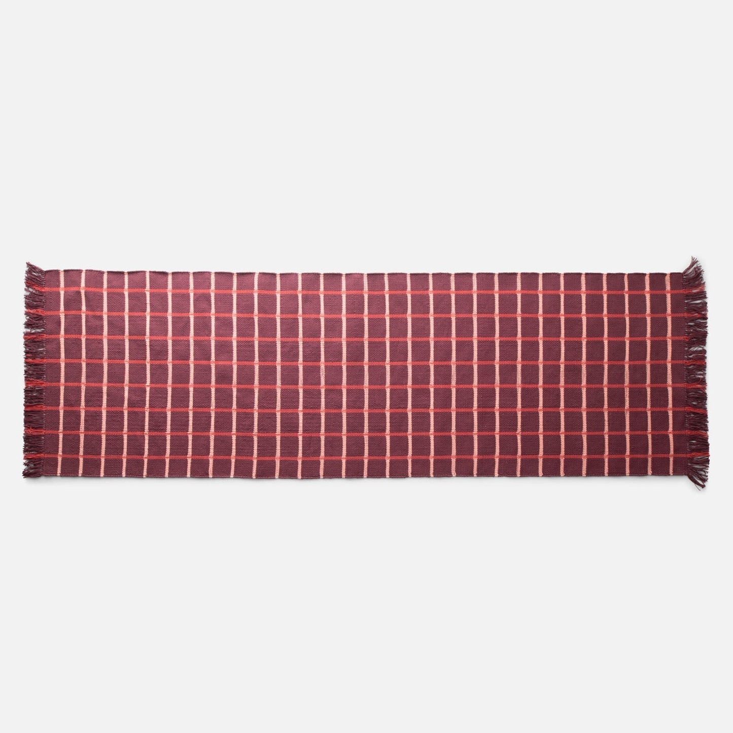 Top-down view of Cotton Grid Flatweave Rug in red showcasing large contrasting grid pattern and fringed ends with white studio background