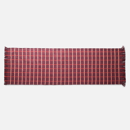 Top-down view of Cotton Grid Flatweave Rug in red showcasing large contrasting grid pattern and fringed ends with white studio background
