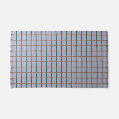 Top view of Cotton Grid Flatweave Rug showcasing large grid pattern in green and tan with fringed short edge on white background