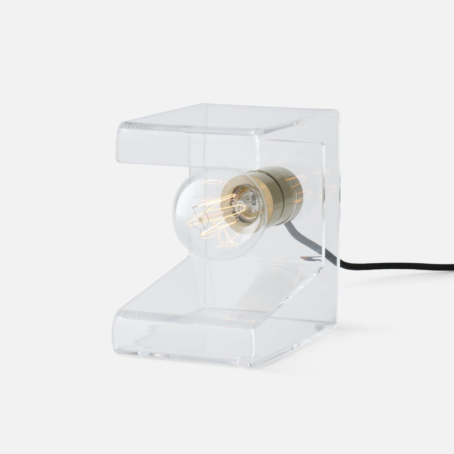 Close-up side view of Pop Light II showing clear acrylic lucite L-shaped body with exposed filament bulb and brass socket on white background