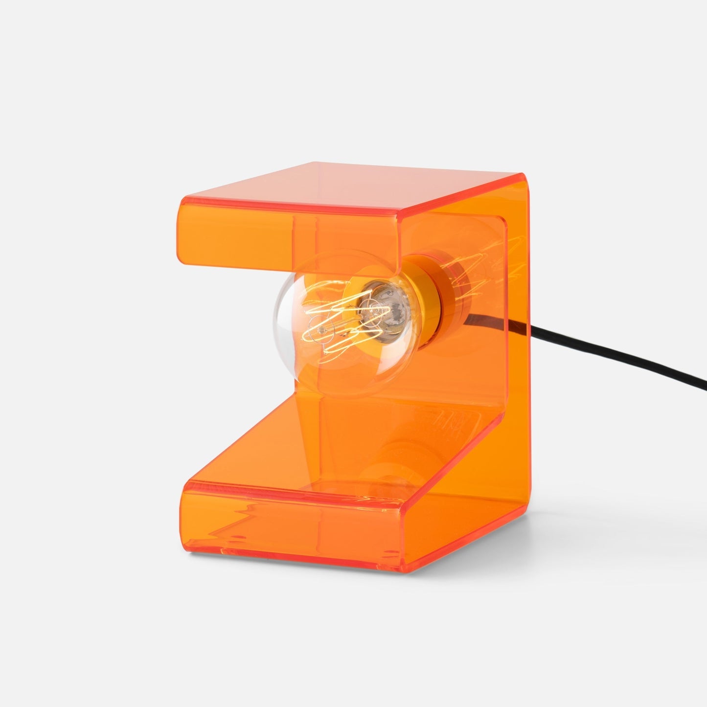 Right side close up of Pop Light II lamp showcasing translucent orange acrylic L shape and exposed filament bulb on white