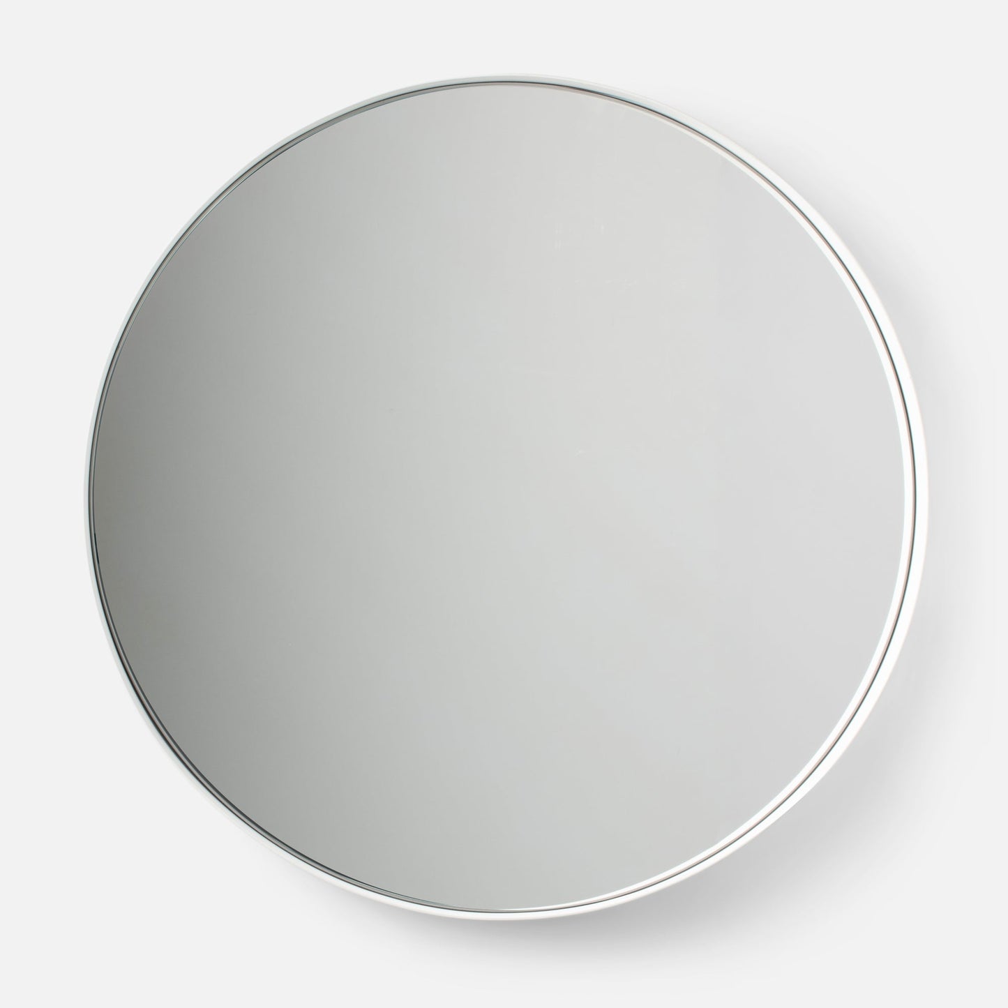 Close-up of top of Leo Mirror 20 by 30 inch in white showcasing thin polished metal frame and round glass with white studio background