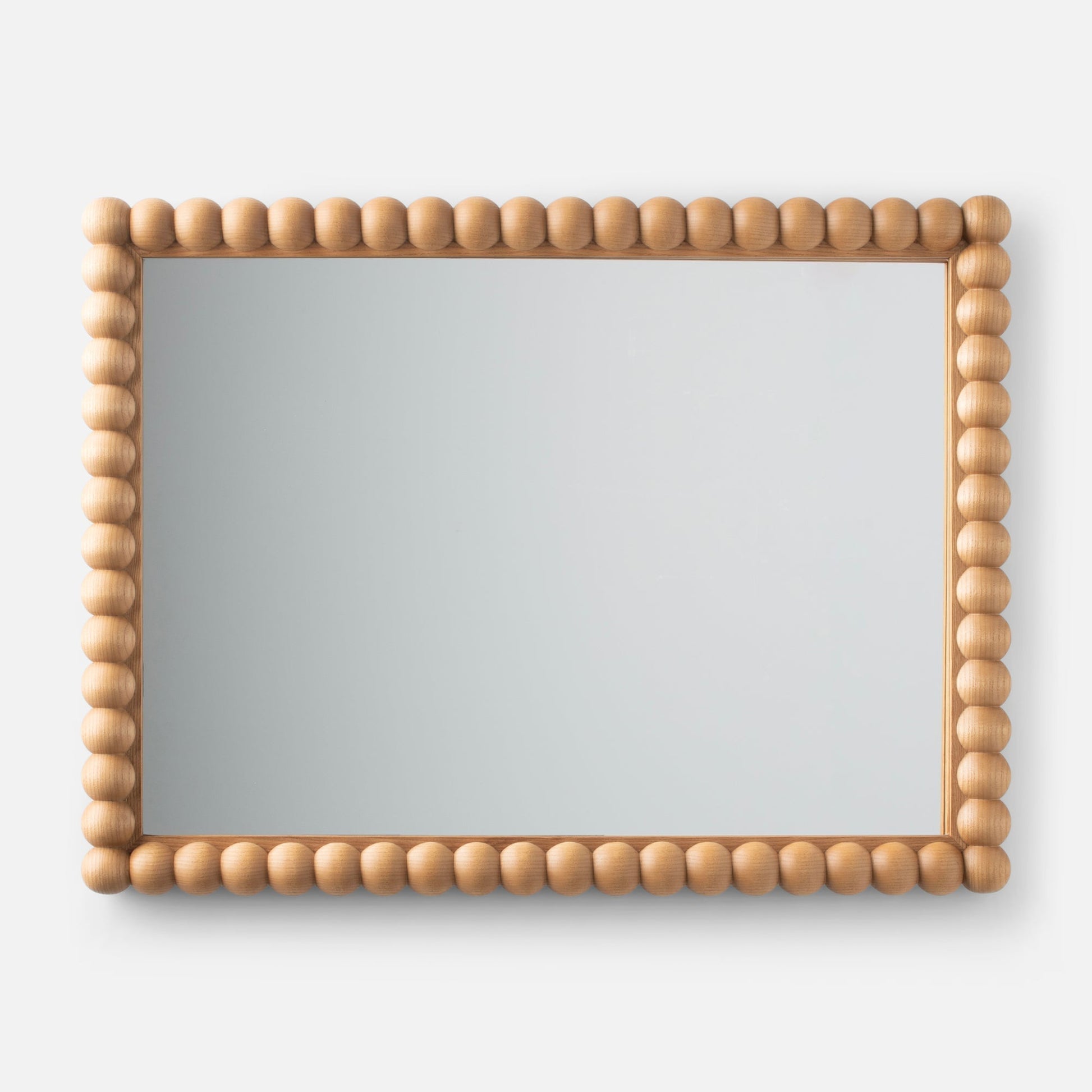 Front view of Bobbin Mirror showcasing a rounded bead-style light wood frame on a neutral gray background