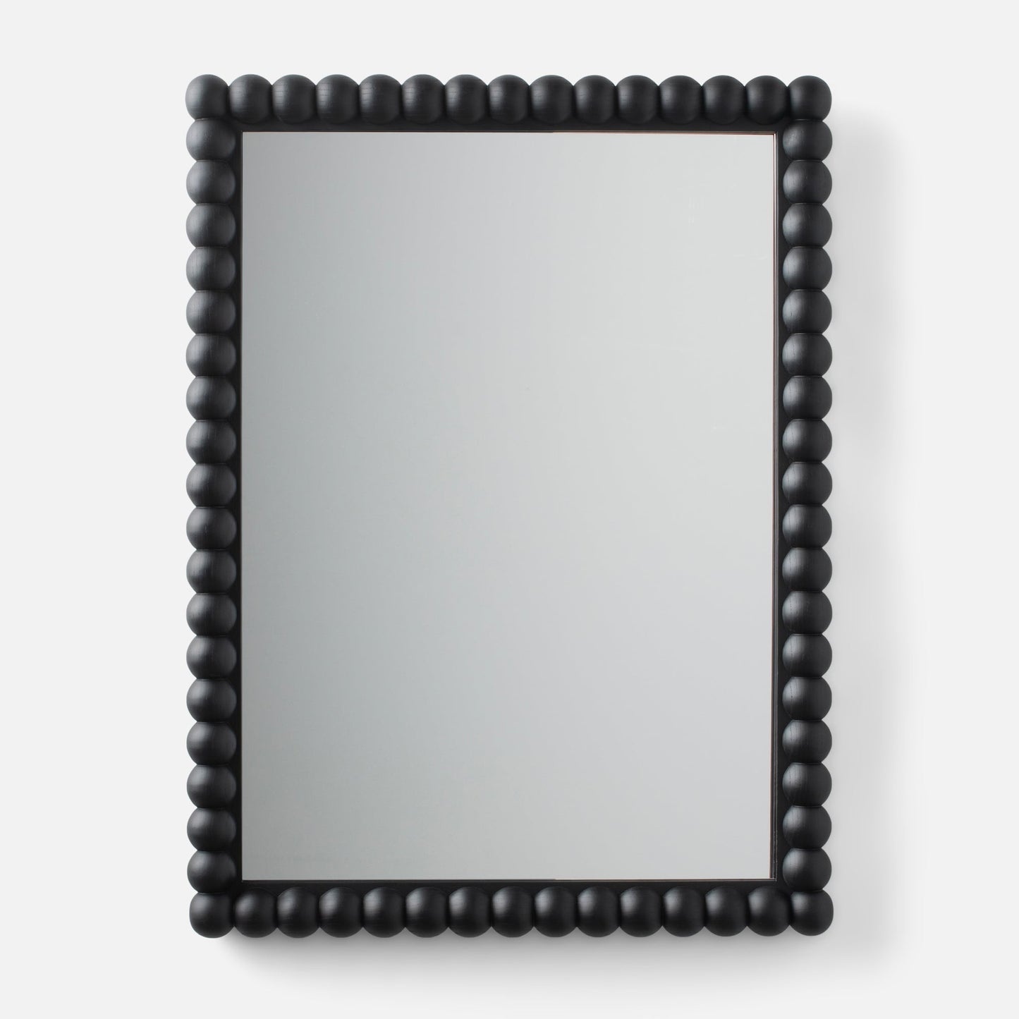 Close-up of Bobbin Mirror showing black beaded wood frame around a rectangular mirror on a light gray background