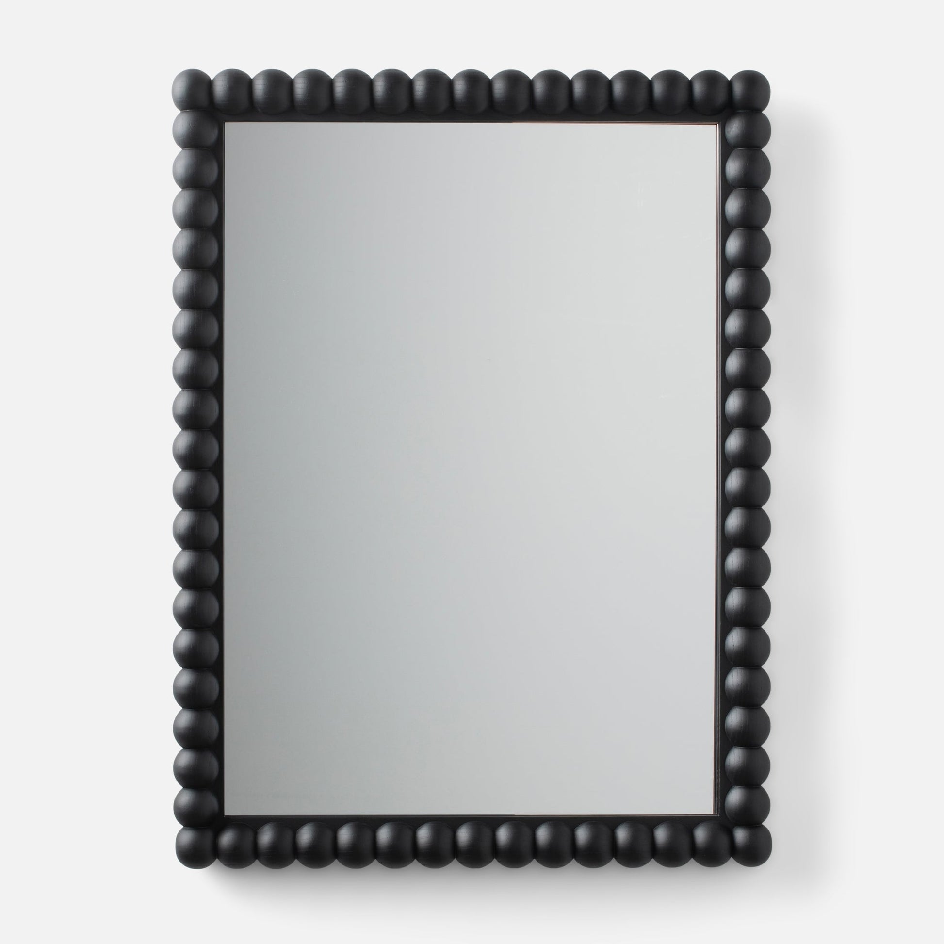 Close-up of Bobbin Mirror showing black beaded wood frame around a rectangular mirror on a light gray background