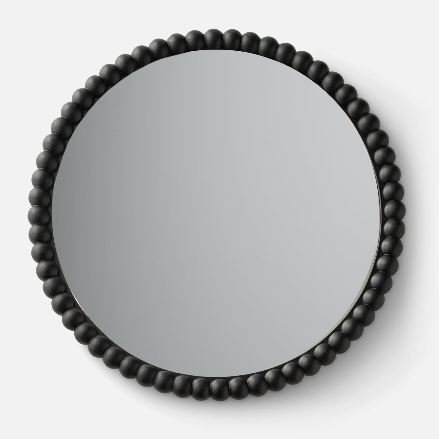 Close-up top view of Bobbin Mirror showing black beaded wooden frame against a white background