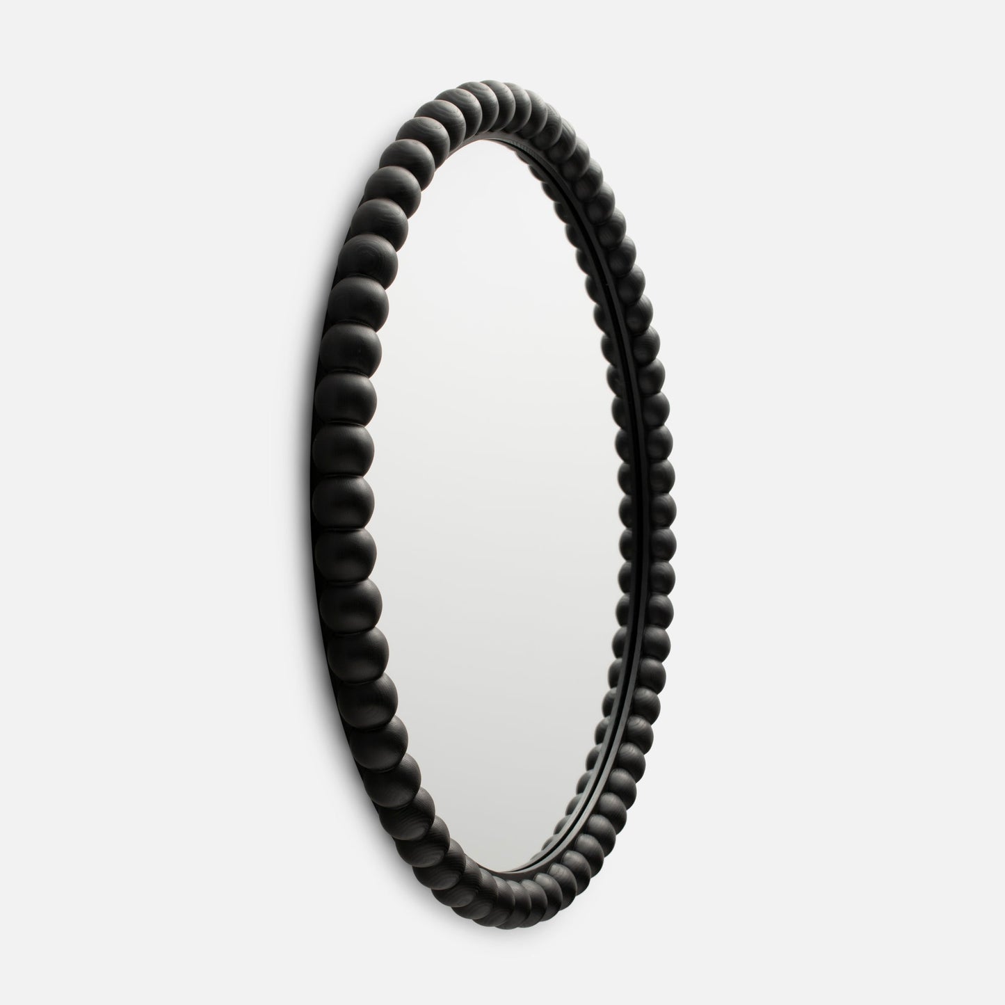 Close-up side view of Bobbin Mirror showcasing its black beaded wooden frame against a white background