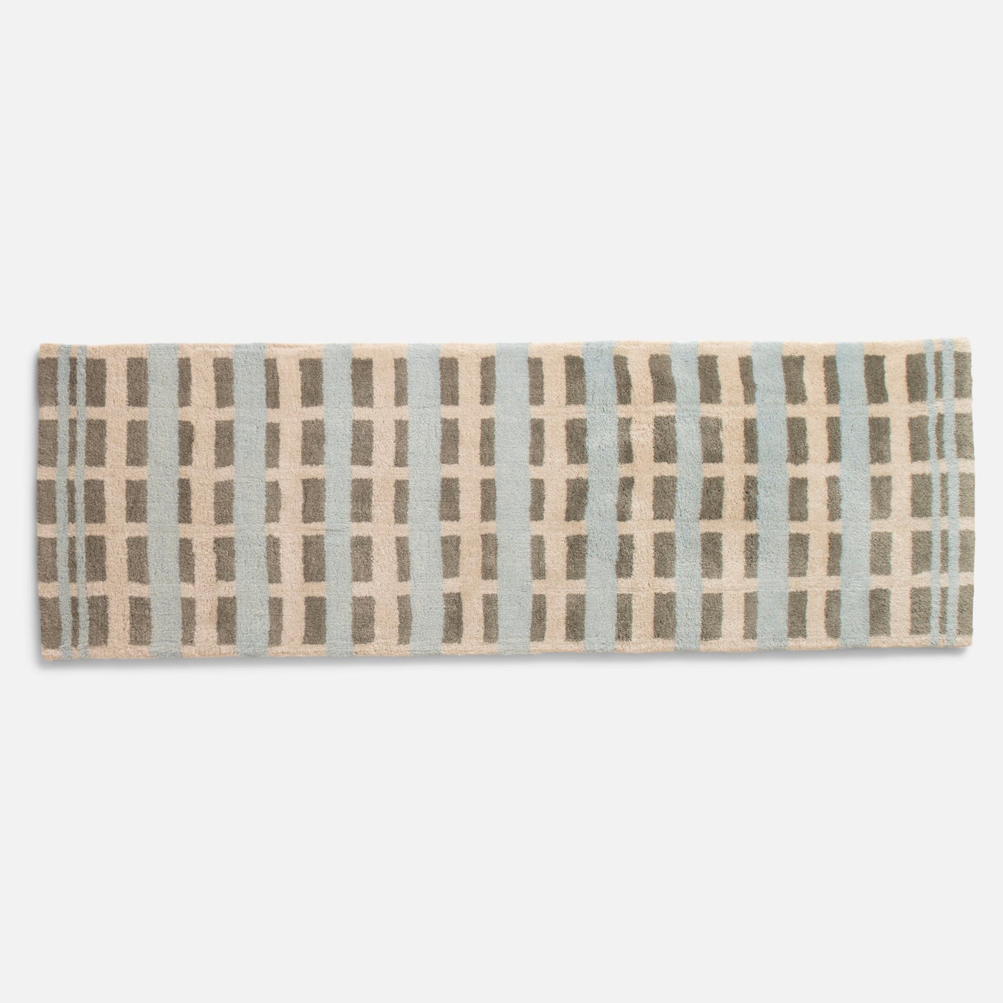 Top-down view of Network Tufted Wool Rug showing high-pile geometric pattern in blue, beige and taupe on white