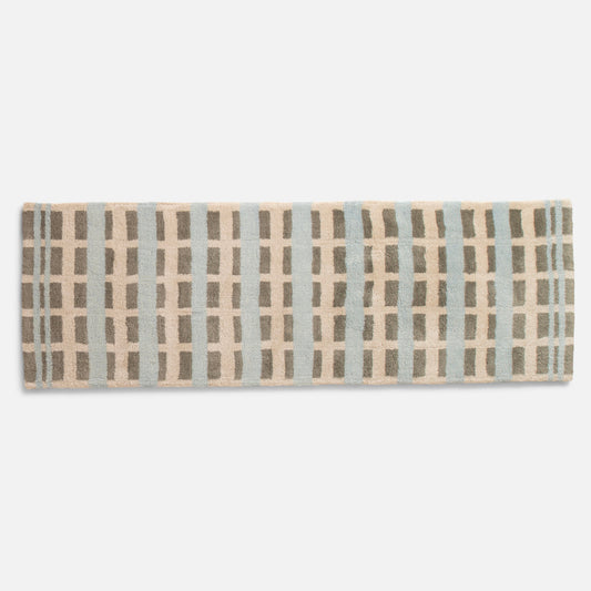 Top-down view of Network Tufted Wool Rug showing high-pile geometric pattern in blue, beige and taupe on white