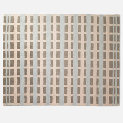 Top-down view of Network Tufted Wool Rug showcasing high-pile geometric grid pattern in soft blue and taupe on white background