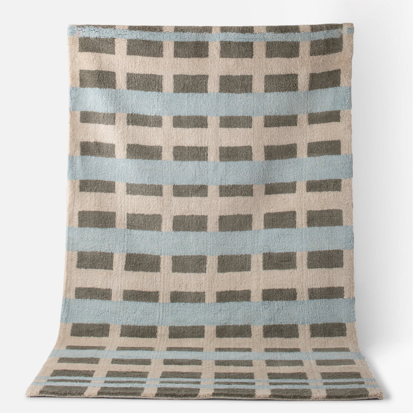 Top view of Network Tufted Wool Rug with blue stripes, gray rectangular grid, and beige high-pile wool