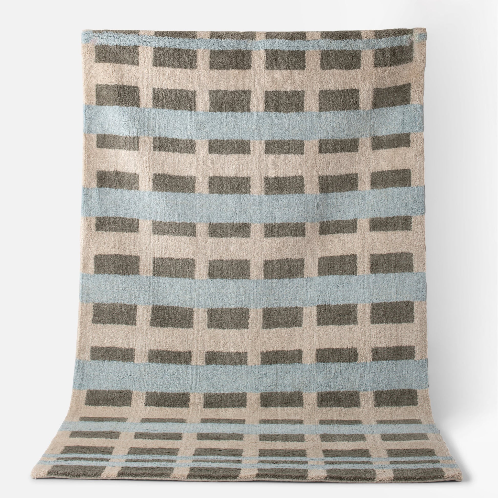 Top view of Network Tufted Wool Rug with blue stripes, gray rectangular grid, and beige high-pile wool
