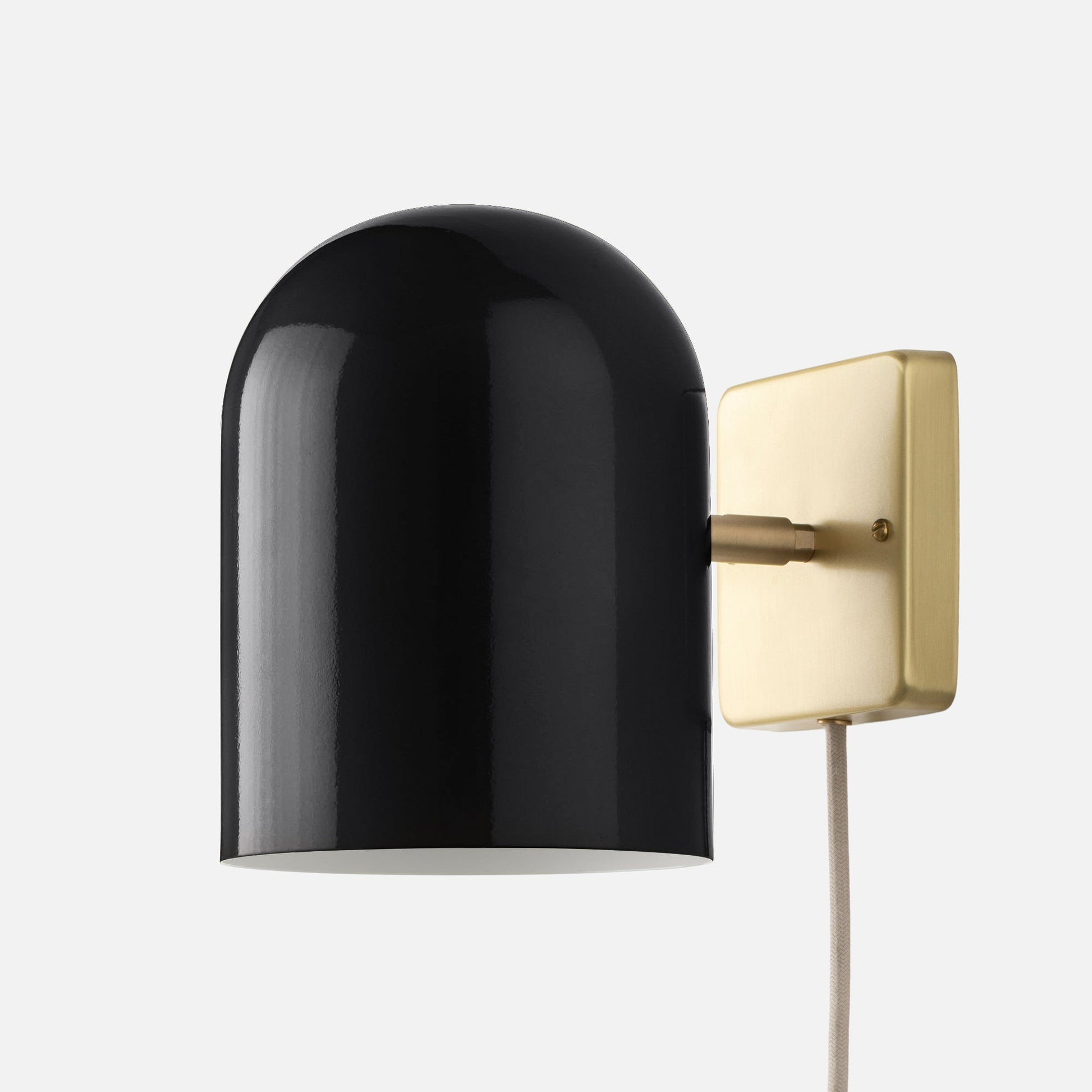 Close-up side view of Allegheny 6-inch plug-in sconce showing black shade, brushed brass wall plate, and fabric cord