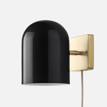 Close-up side view of Allegheny 6-inch plug-in sconce showing black shade, brushed brass wall plate, and fabric cord