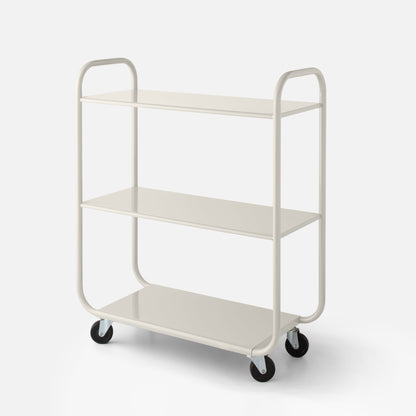 Front three-quarter view of Miller Storage Cart showcasing three shelves, rounded tubular frame, and caster wheels on a pale background
