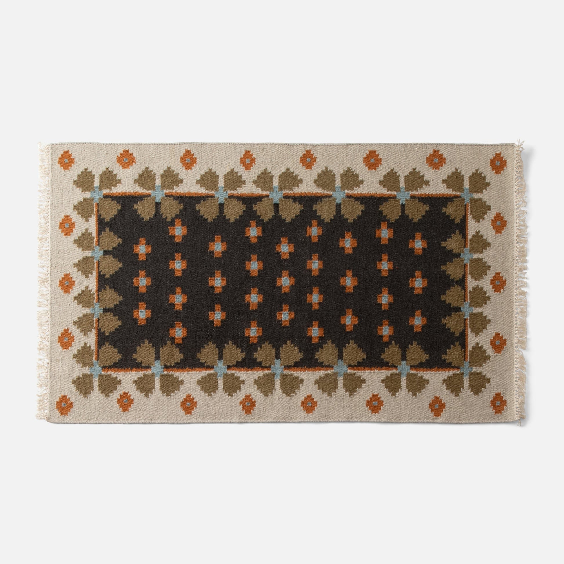 Top-down view of Flora Wool Flatweave Rug with folk floral pattern, dark center and cream border, rust and olive accents on light gray background