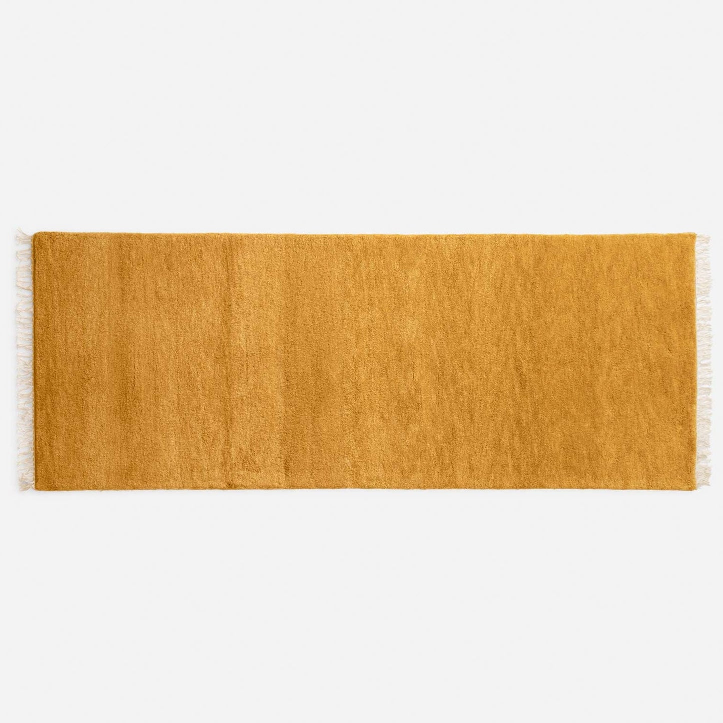 Top view of Mesa Wool Rug showcasing hand-loomed cut pile and tasseled fringe on a white background