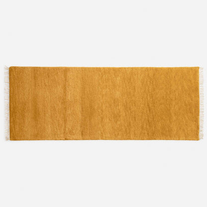 Top view of Mesa Wool Rug showcasing hand-loomed cut pile and tasseled fringe on a white background