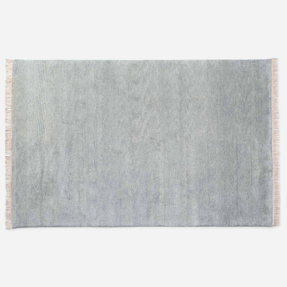 Top-down view of Mesa Wool Rug showcasing hand-loomed cut-pile New Zealand wool and natural fringe on a white background