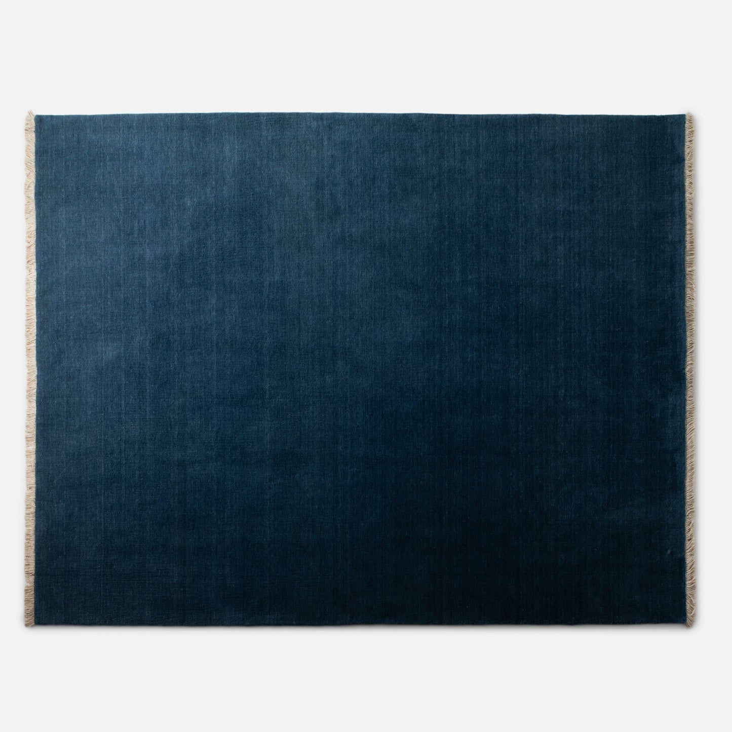 Top-down view of Mesa Wool Rug showing hand-loomed 100 percent New Zealand wool pile and natural fringe on white background
