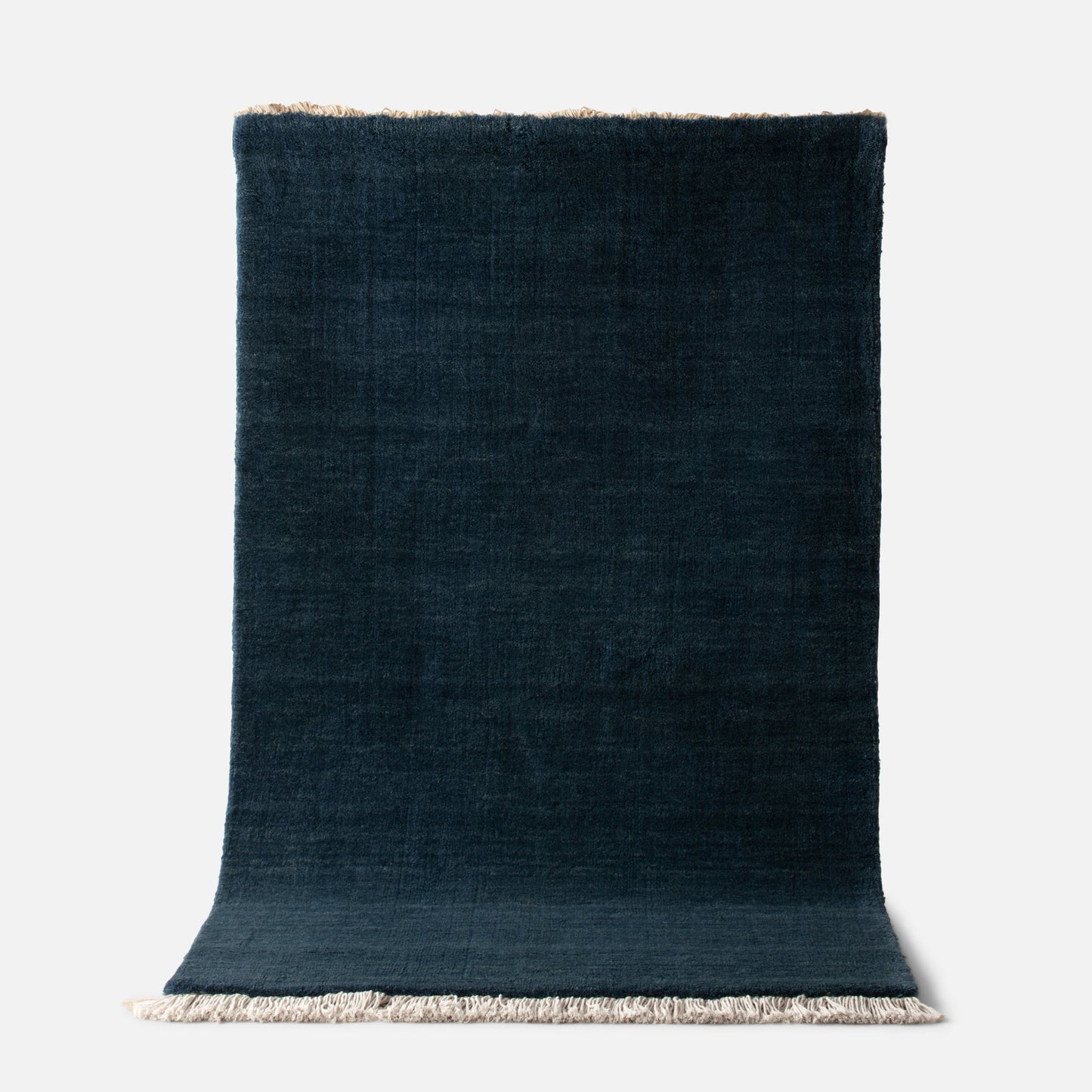 Top view of Mesa Wool Rug showing hand-loomed New Zealand wool pile and fringe on white background