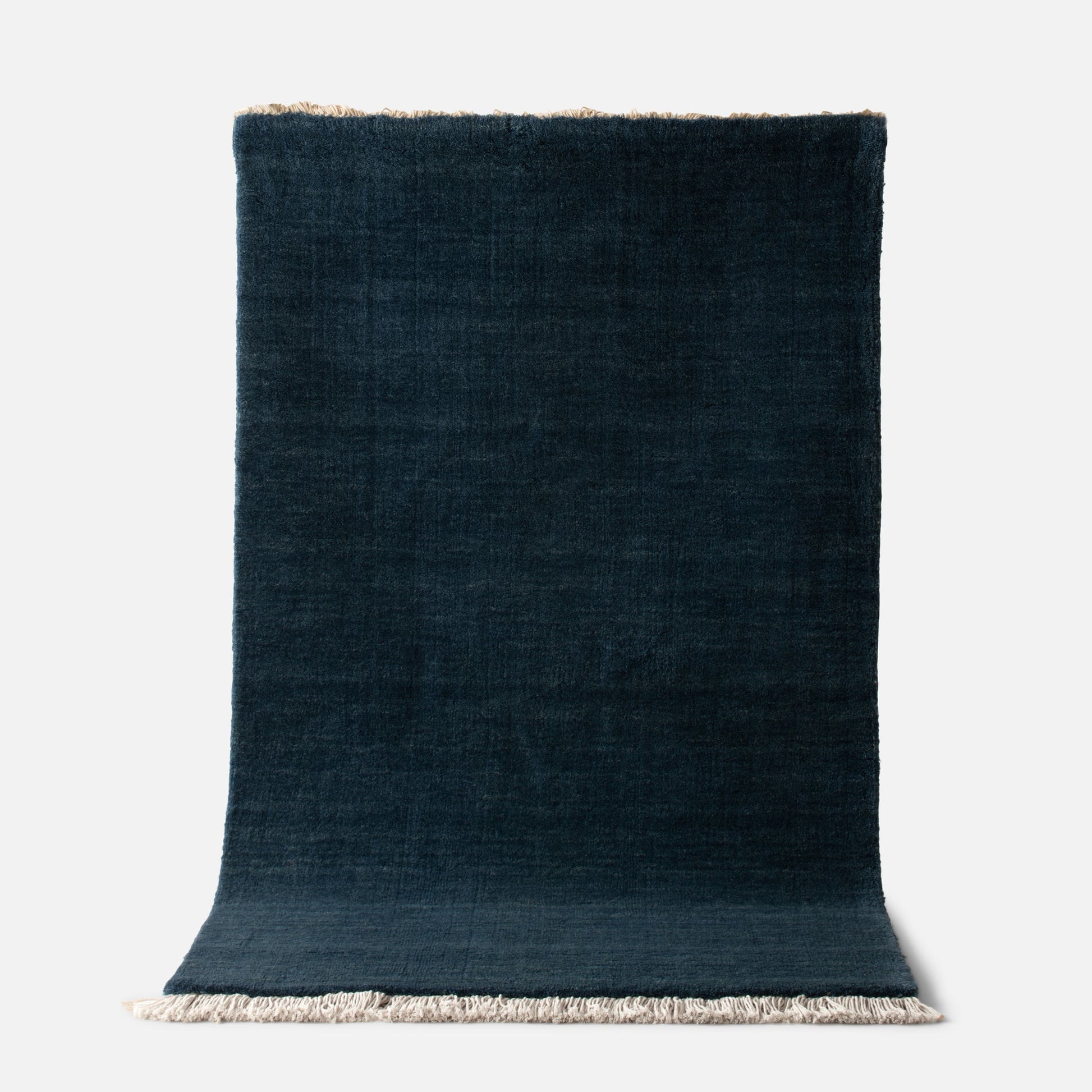 Top view of Mesa Wool Rug showing hand-loomed New Zealand wool pile and fringe on white background