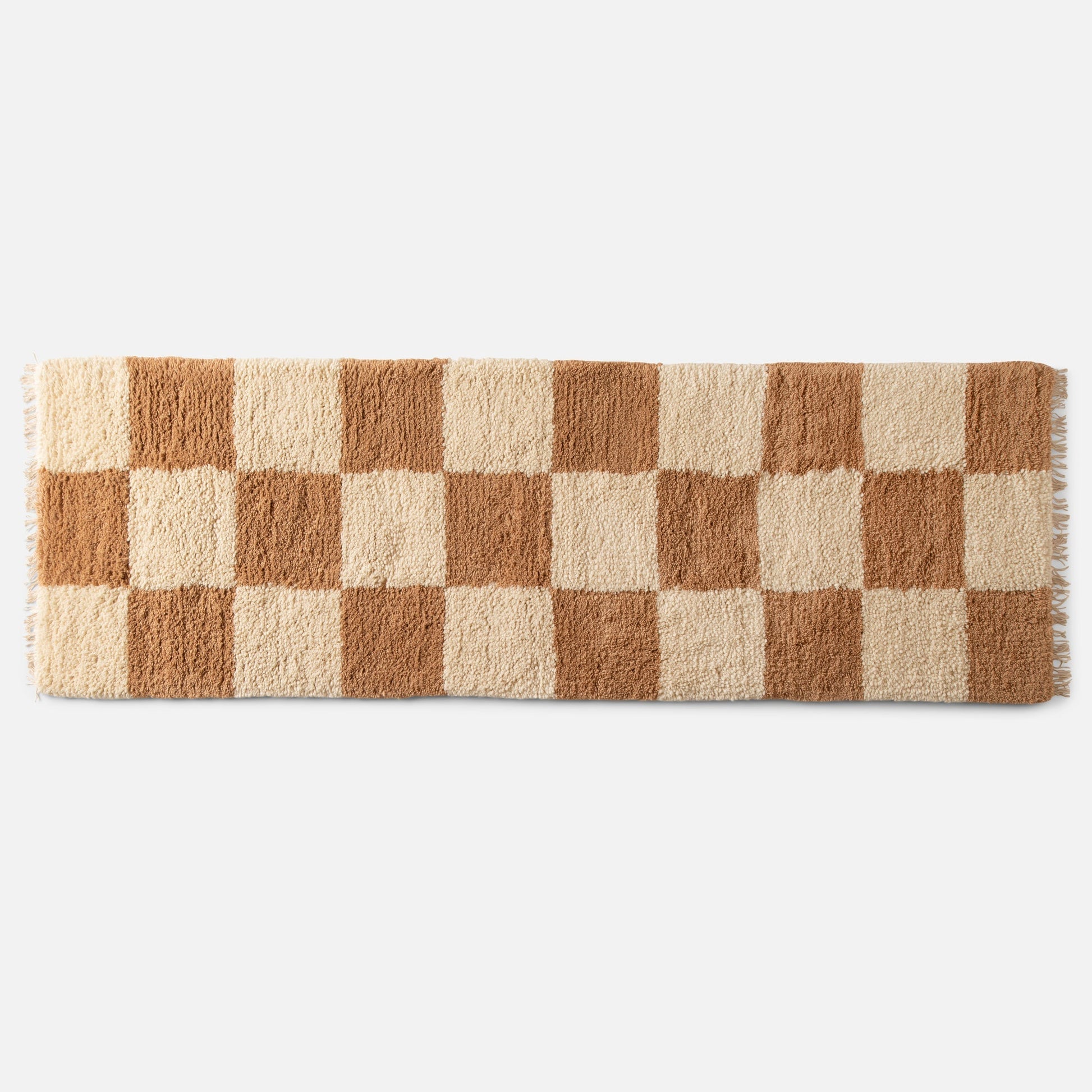 Top view of Schoolhouse x Clare V. Jacques shag wool rug showcasing high-pile checked pattern and fringe on white background