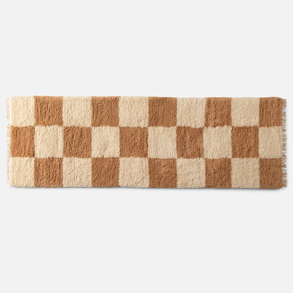 Top view of Schoolhouse x Clare V. Jacques shag wool rug showcasing high-pile checked pattern and fringe on white background