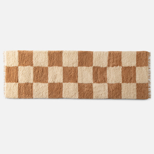 Top view of Schoolhouse x Clare V. Jacques shag wool rug showcasing high-pile checked pattern and fringe on white background