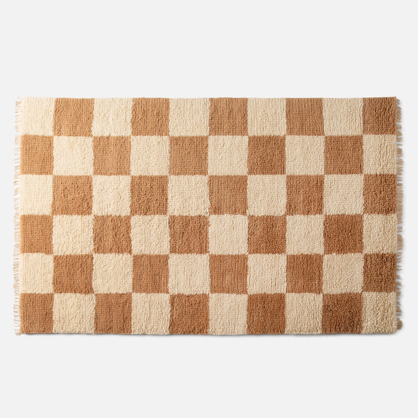 close-up top view of Jacques shag wool rug showcasing cream and tan checkerboard pattern, high-pile wool texture, and fringe on a white background